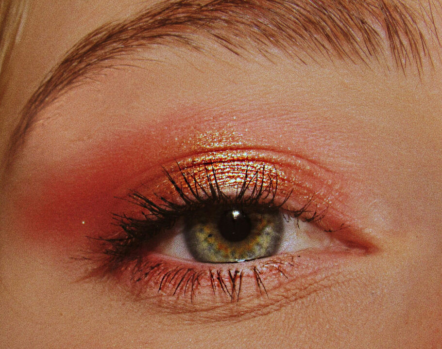 zoomed in photo of woman'e eye with red and gold eyeshadow