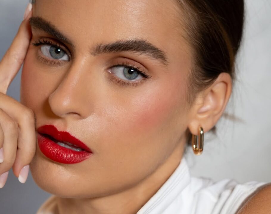 Model with dark eyebrows and bold red lipstick