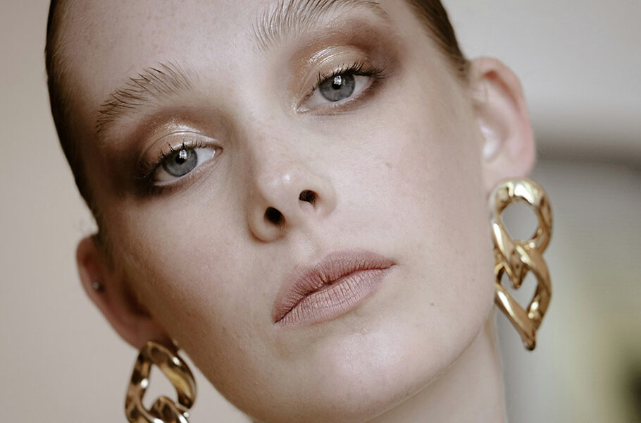 woman wearing makeup and gold earrings